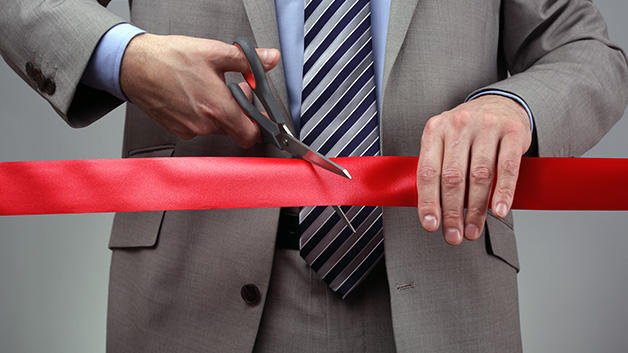 Cutting a red ribbon with scissors