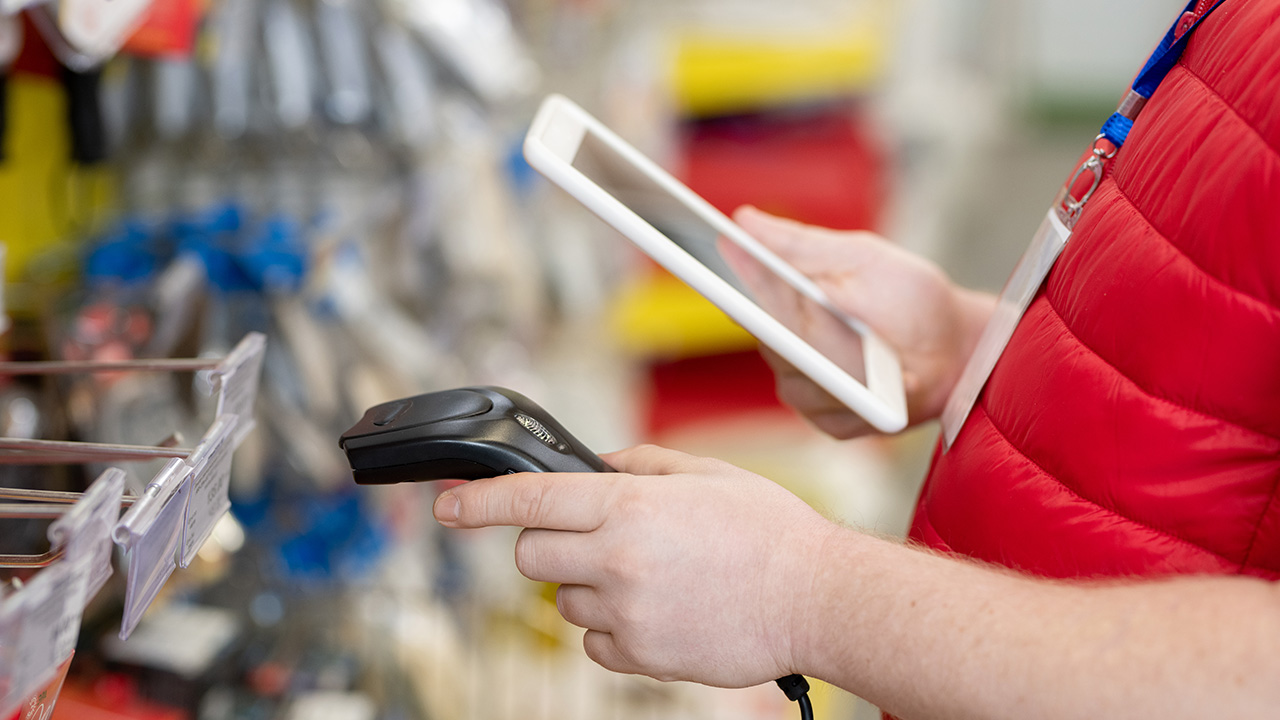 Sales manager scanning price tags in hardware store