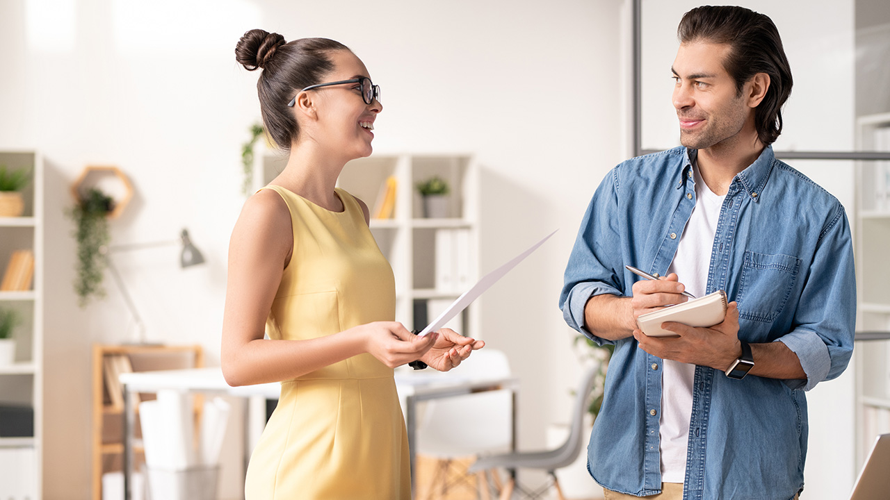 Young businesswoman analyzing sales report with colleague