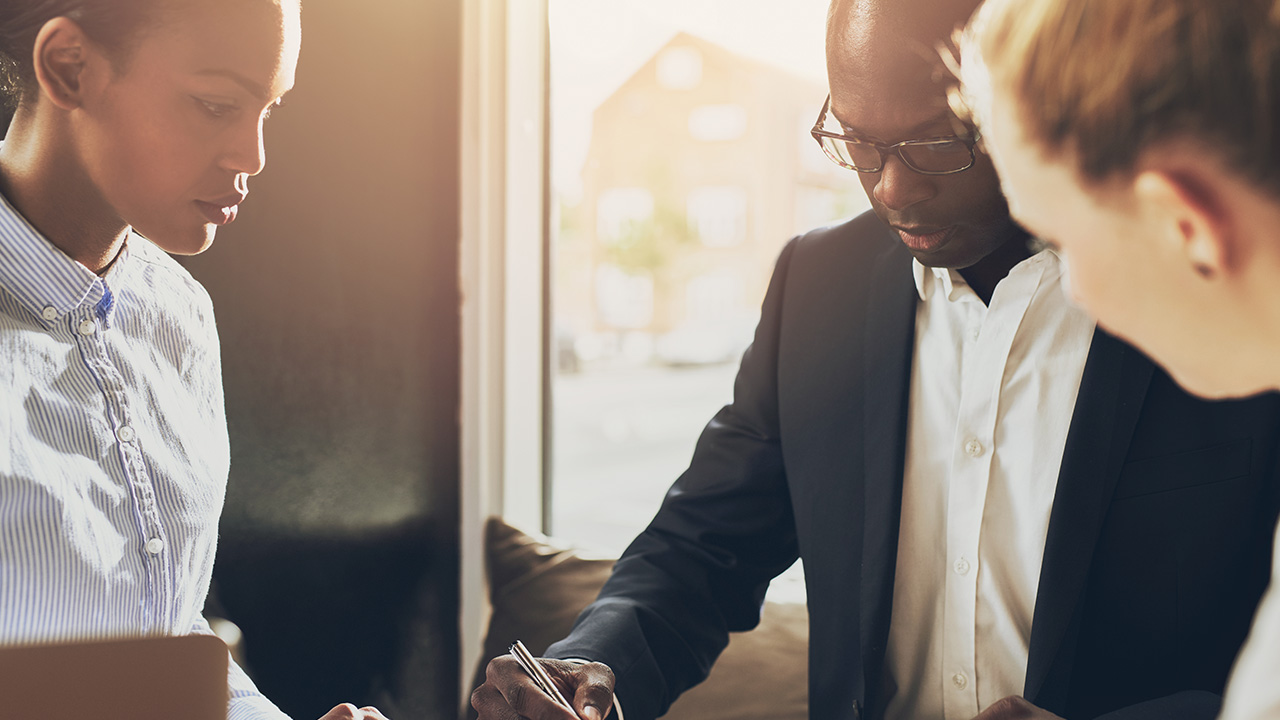 Black executive explains business plan to two female investors