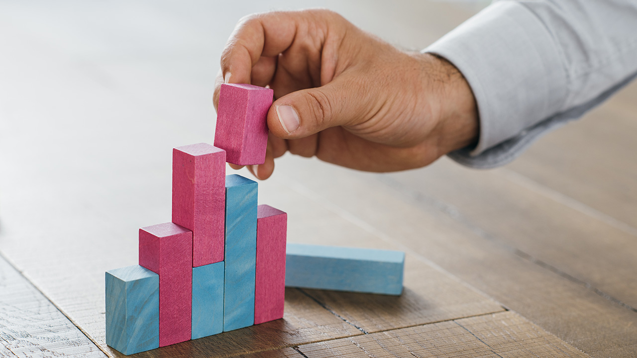 Businessman building a successful financial graph using wooden toy blocks