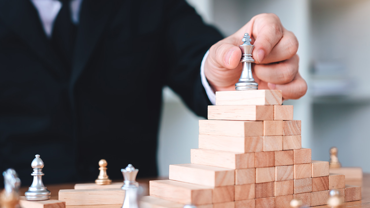 Businessman moving chess pieces to represent leadership