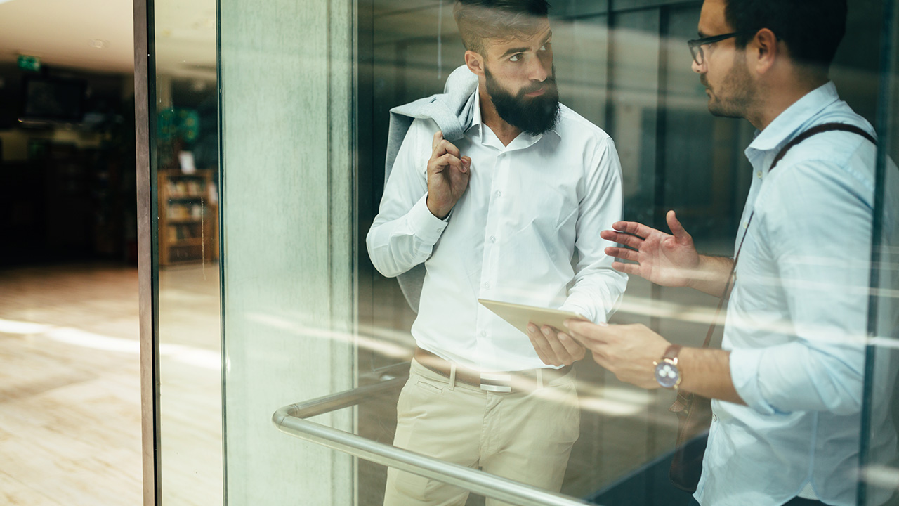 Two businessmen talking in an elevator