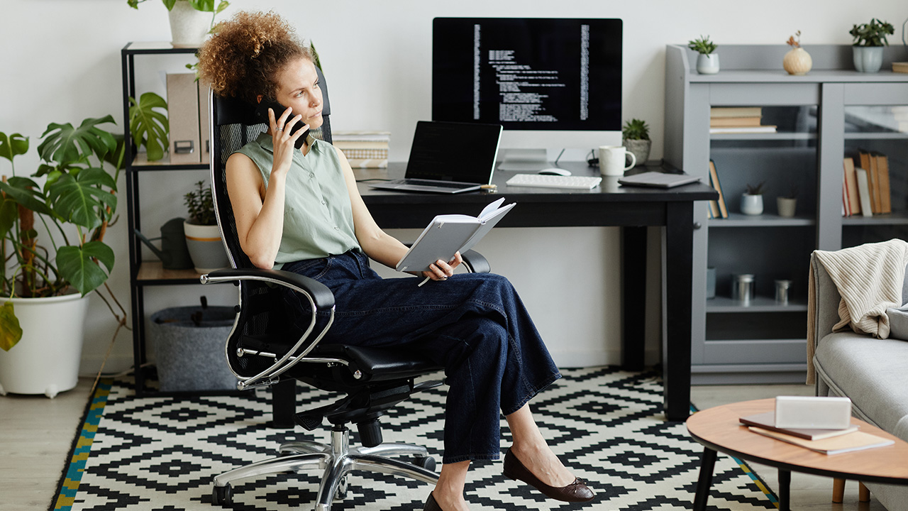 Elegant businesswoman sitting on chair with notebook