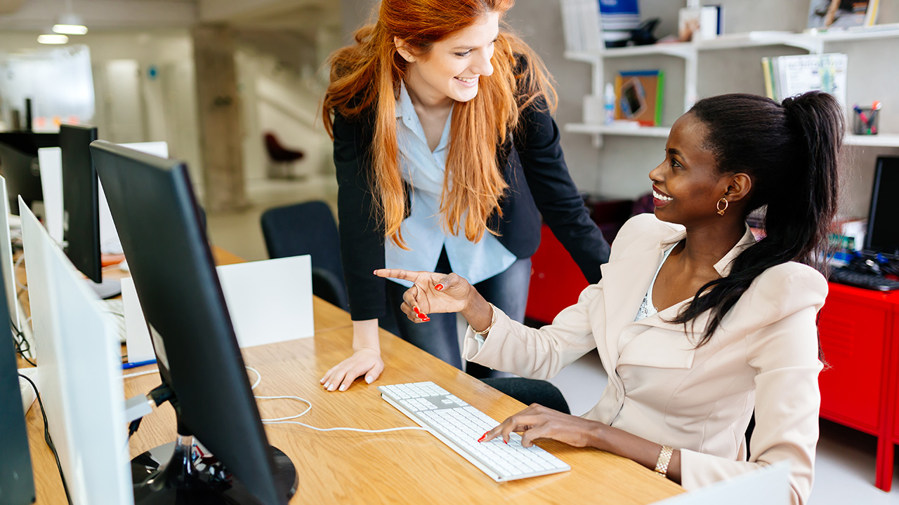 Businesswoman supervising employee in modern office