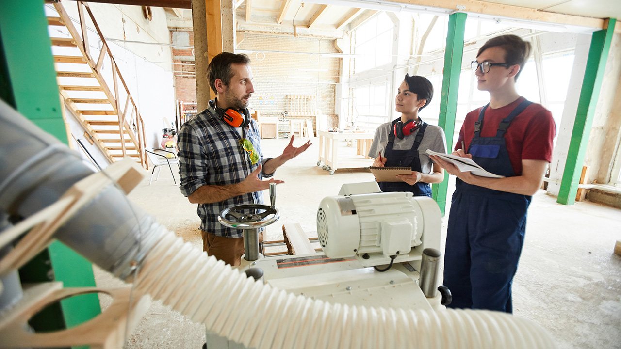 Carpenter explaining how to work with modern machine