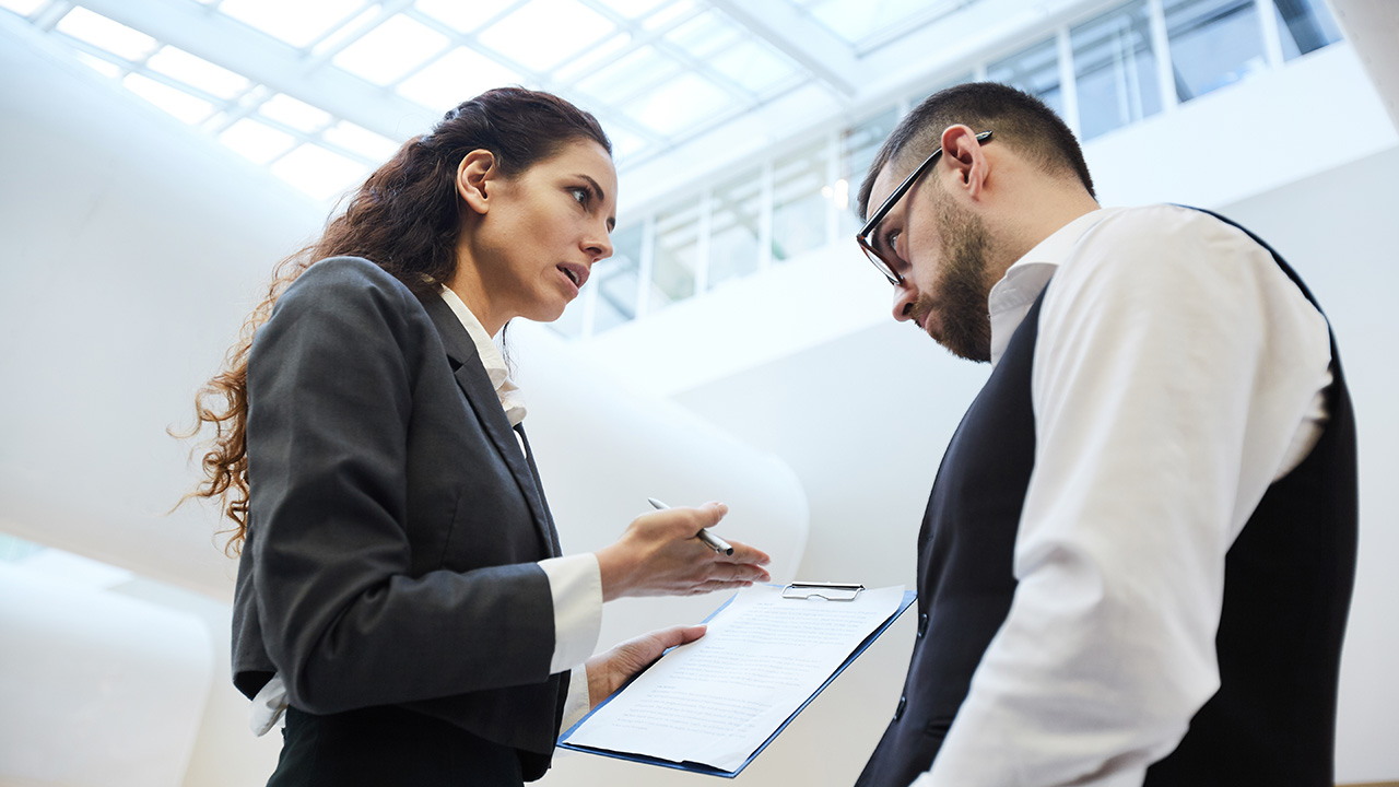 Confused businessman looking at his colleague over eyeglasses