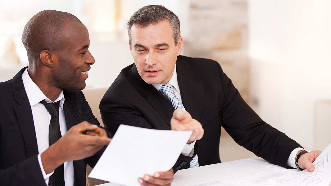 Two cheerful business people in formalwear discussing something