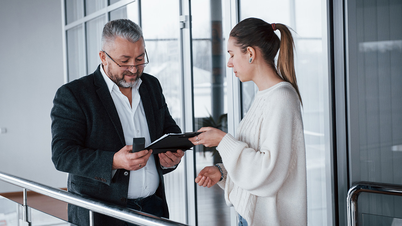 Employee showing documents to her good boss