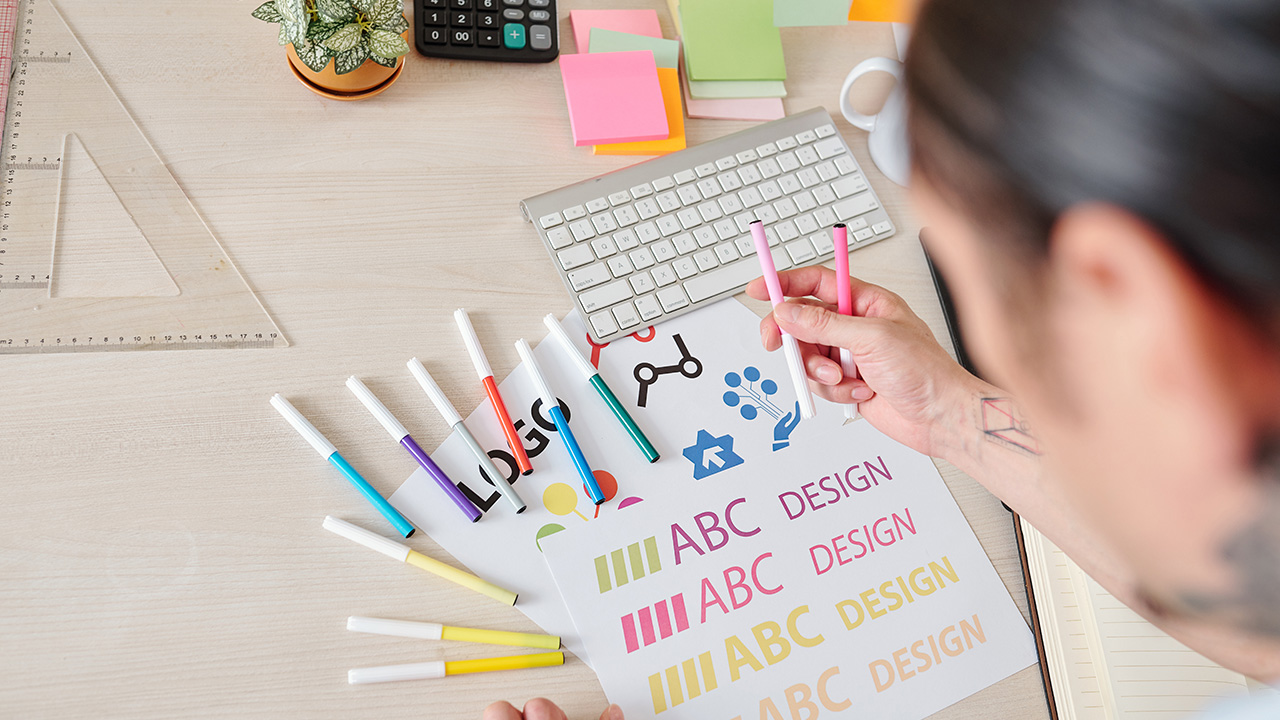 Designer creating company logo using colorful felt-tip pens