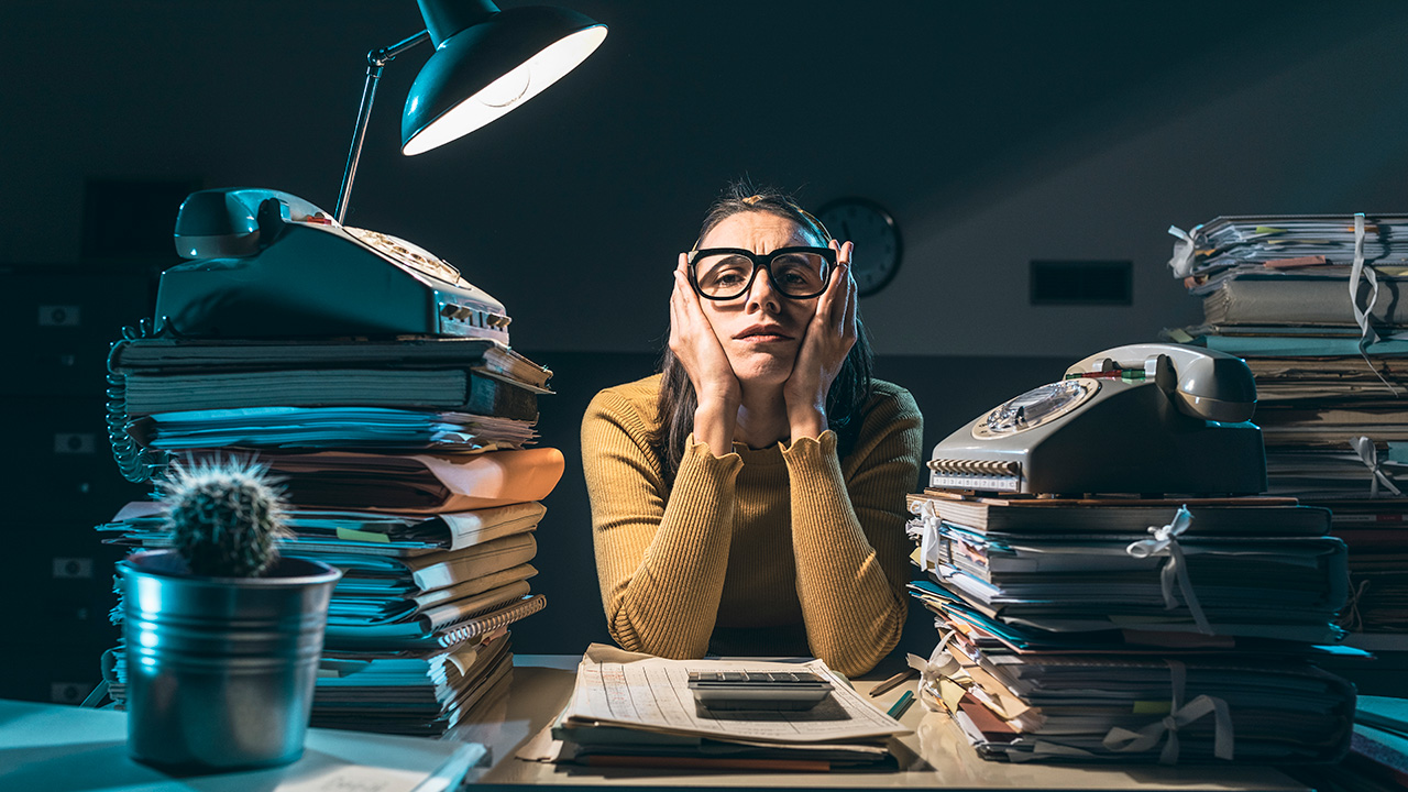 Woman Busy at Cluttered Desk