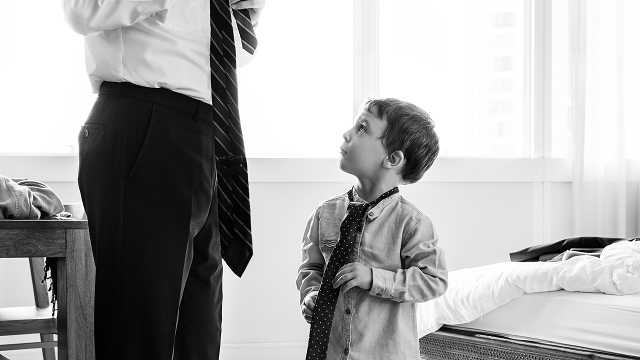 Father teaching son how to tie a tie