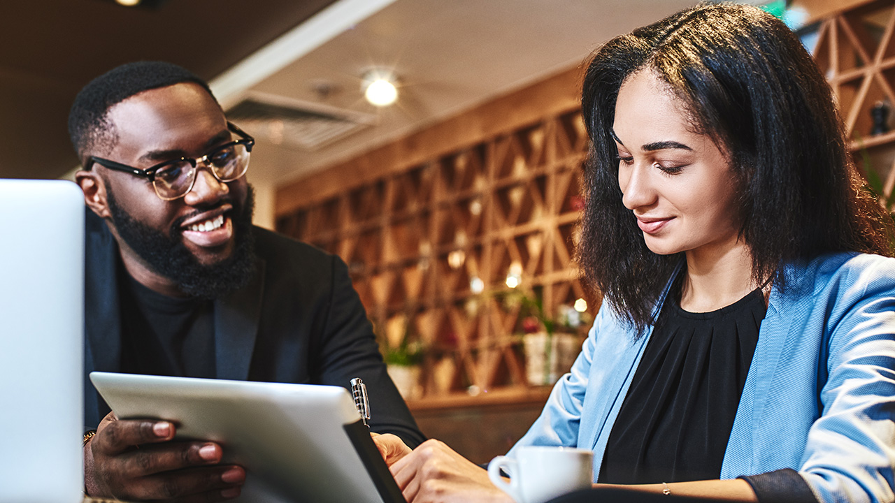 Cheerful businessman and businesswoman having lunch at restaurant