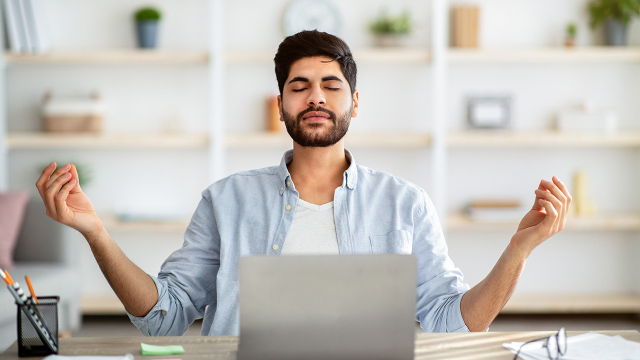 Entrepreneur meditating while working on laptop