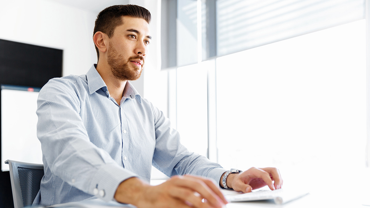 Business Guy Sitting at Desk Trying to Stay Focused