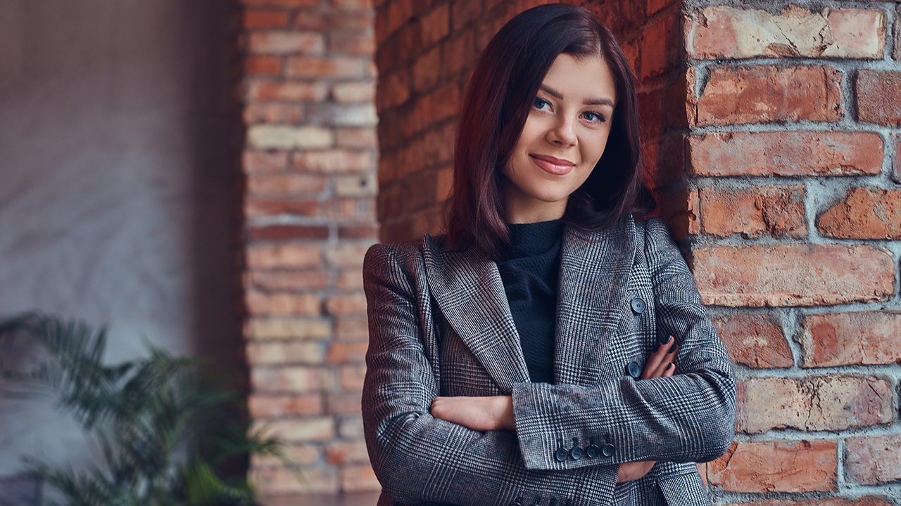 Businesswoman leaning against a brick wall