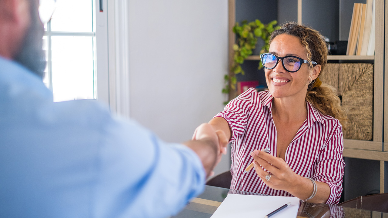 Smiling female manager hiring male candidate at job interview