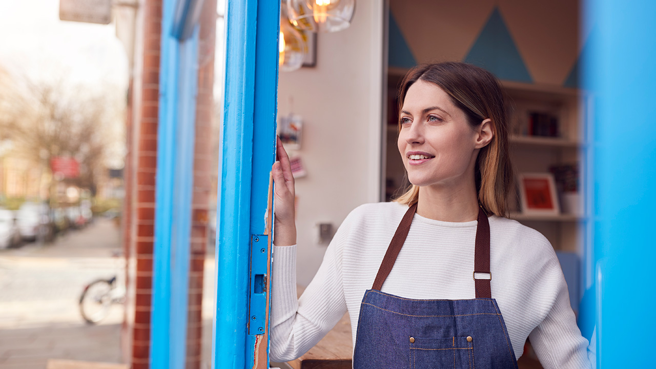Smiling Female Small Business Owner Standing In Shop Doorway