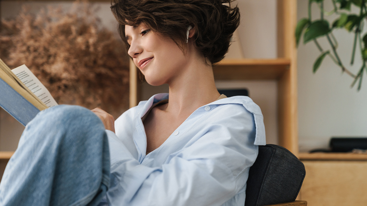 Smiling young woman entrepreneur reading book