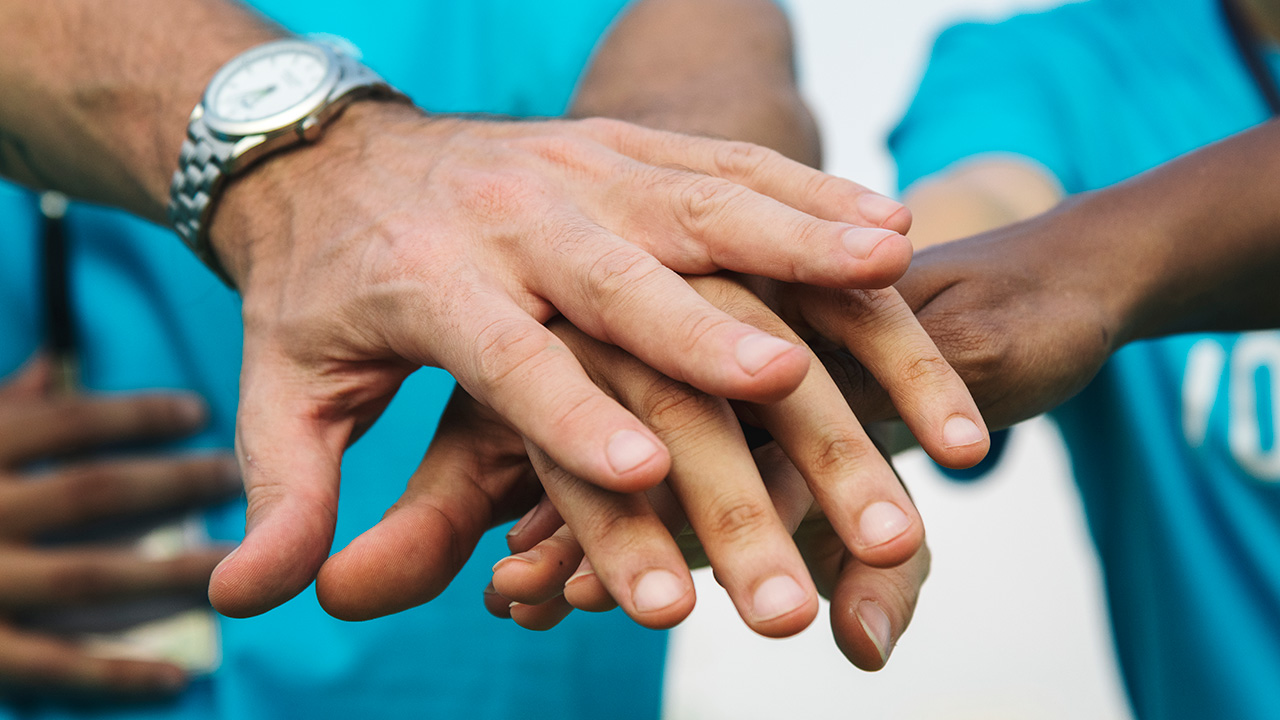 Team of volunteers stacking hands