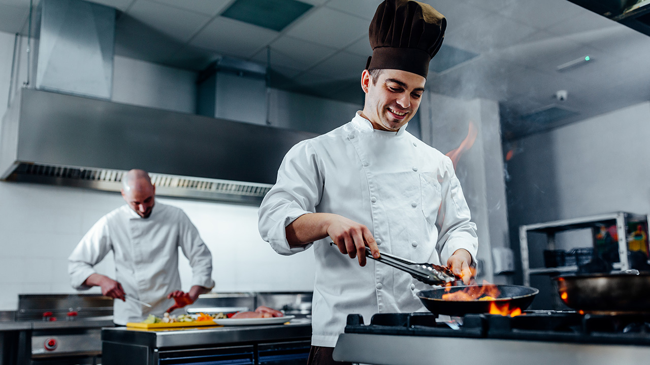 Two young chefs in the kitchen preparing food