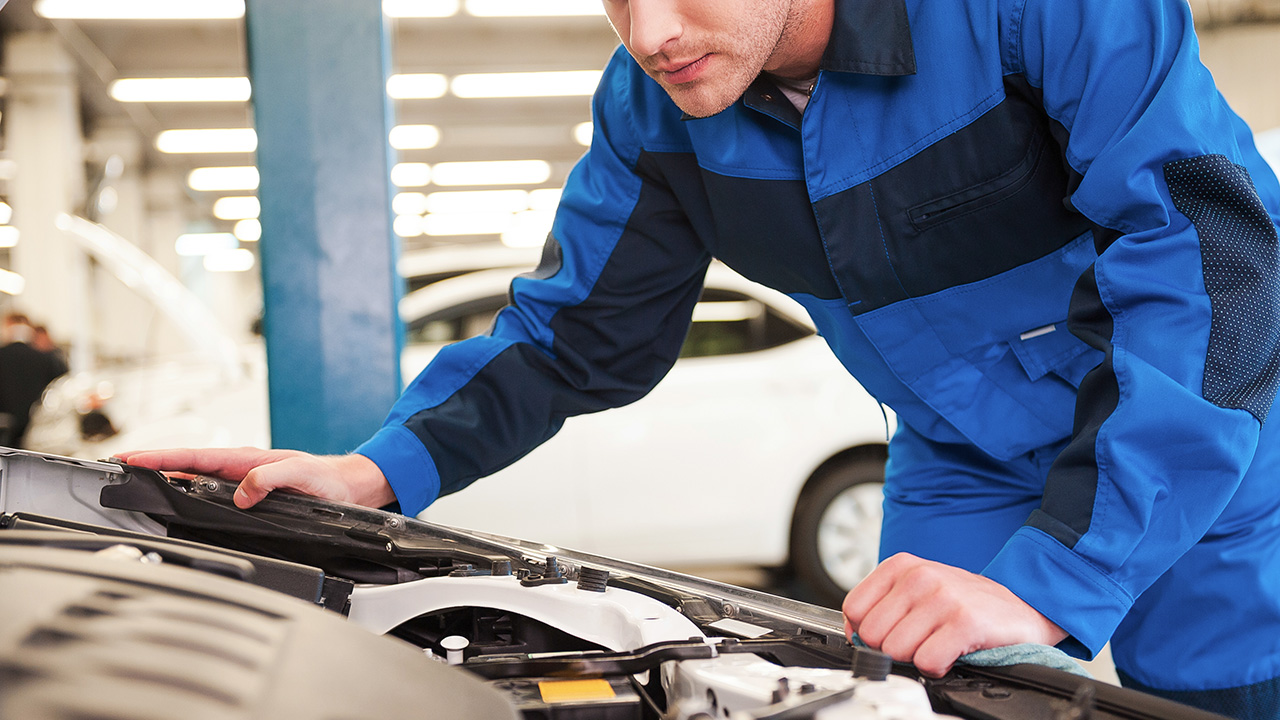 Owner of car shop working on an engine