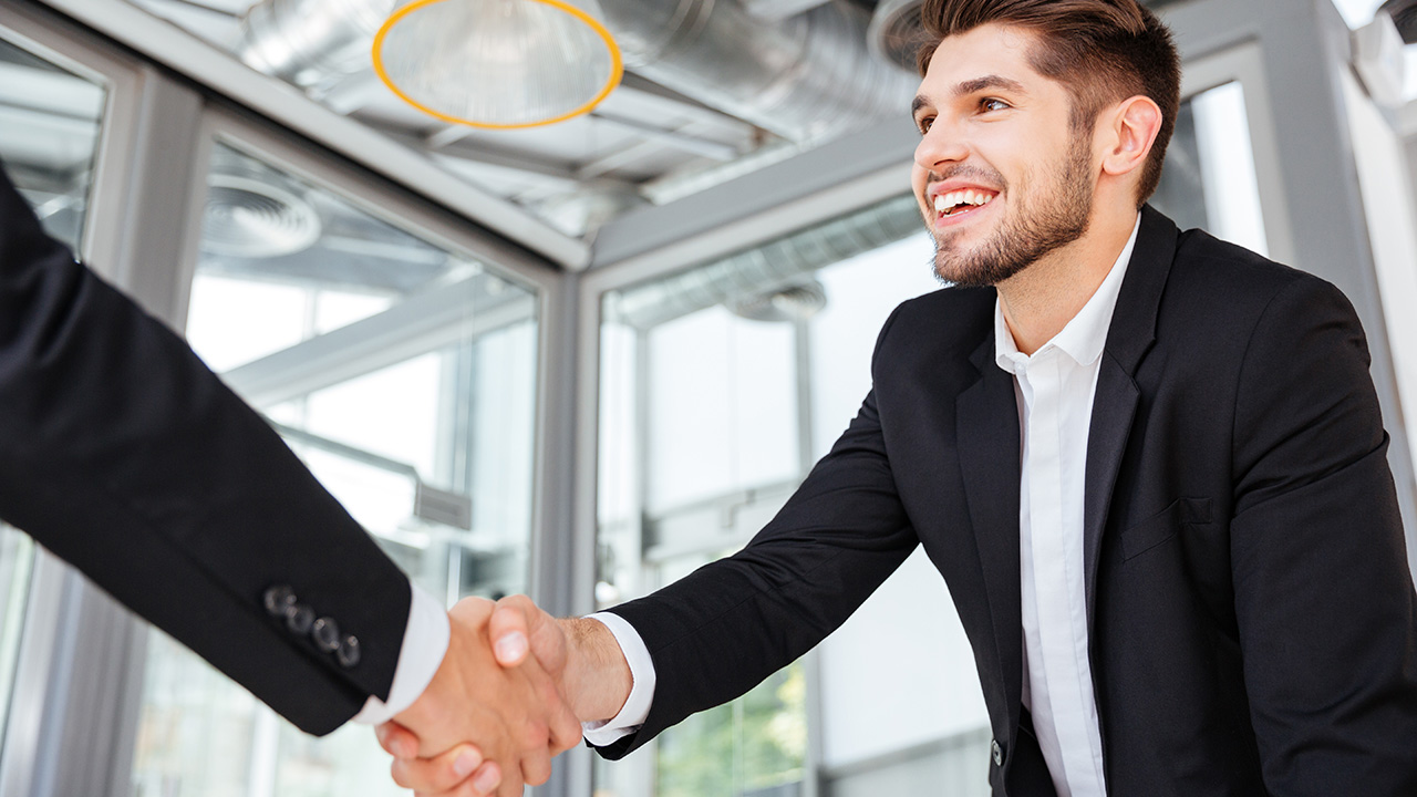 Two successful businessmen shaking hands on business meeting in office