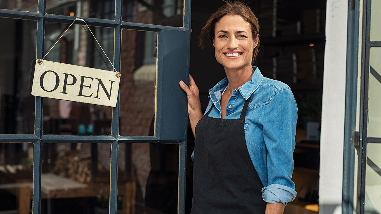 Female business owner at small business entrance