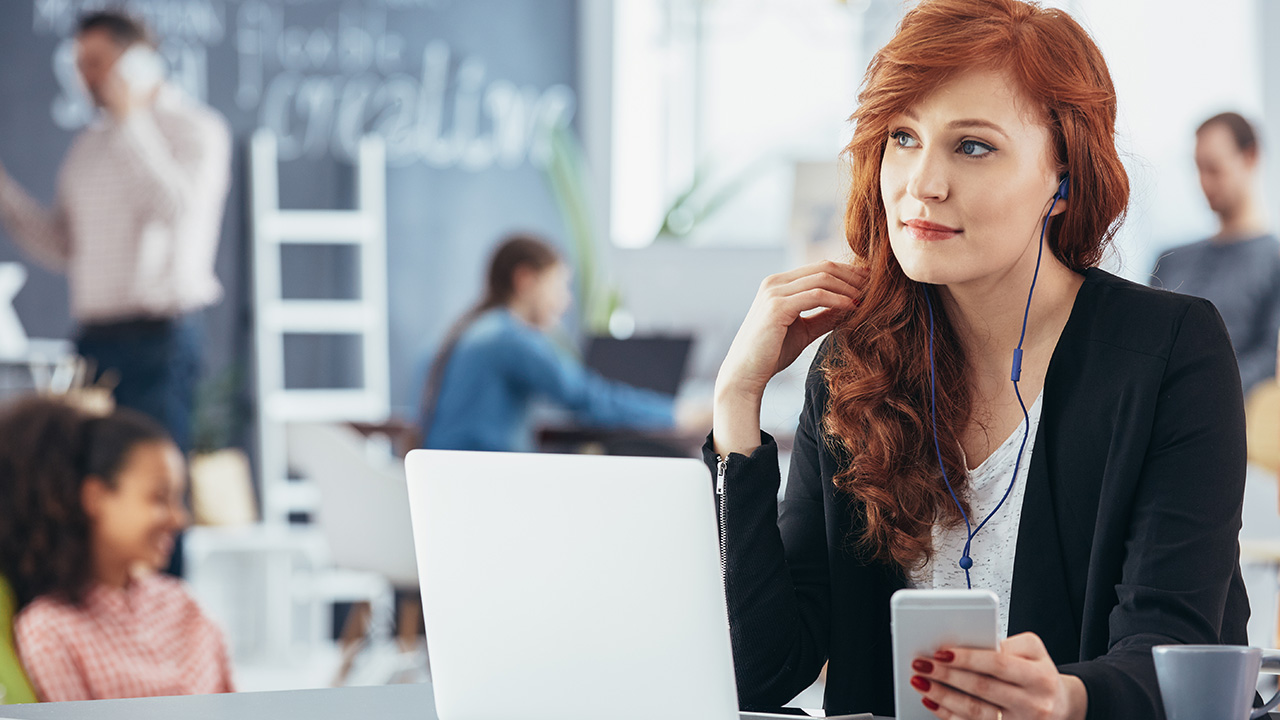 Woman listening to music while working in startup business office