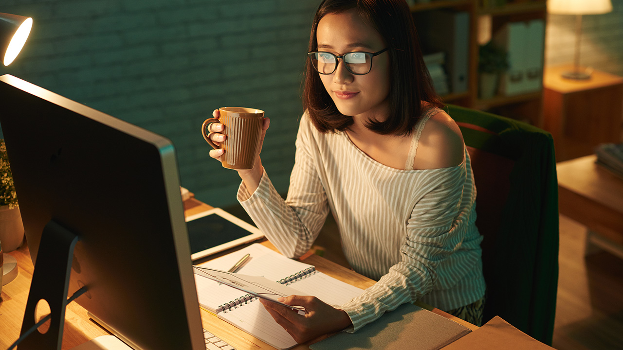 Smiling female entrepreneur working from home late at night