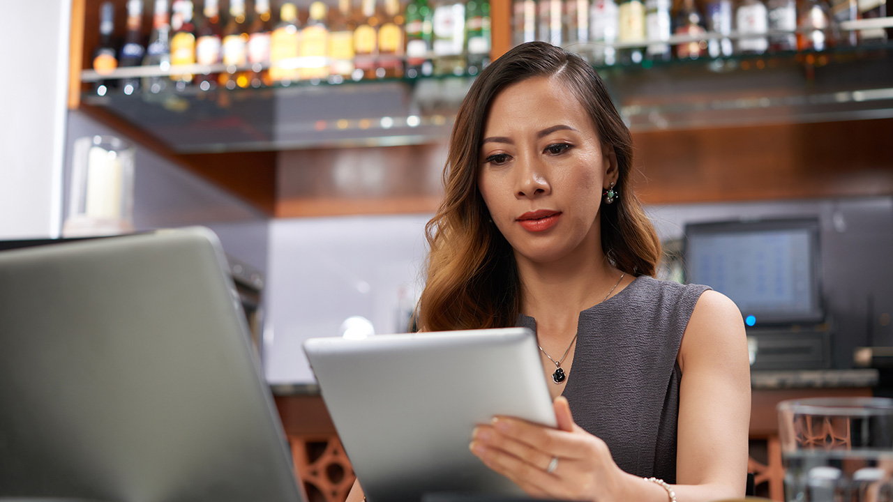 Female bar owner with tablet computer working
