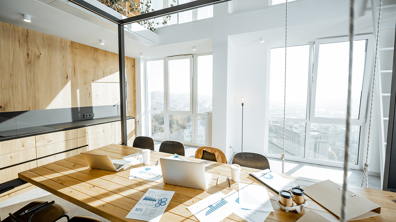 Workplace with large wooden table and office supplies