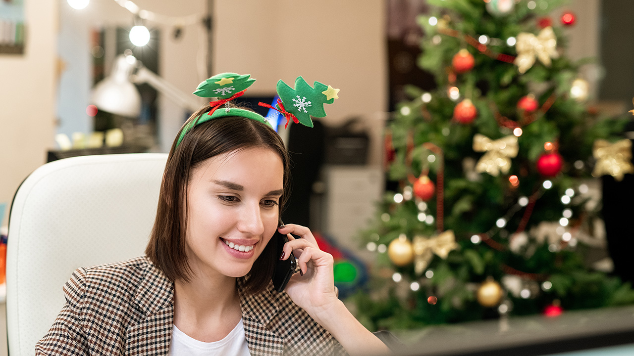 Young businesswoman talking to clients on Christmas on mobile phone