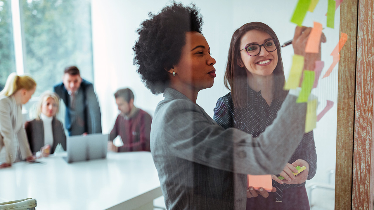 Business Women Brainstorming with Sticky Notes