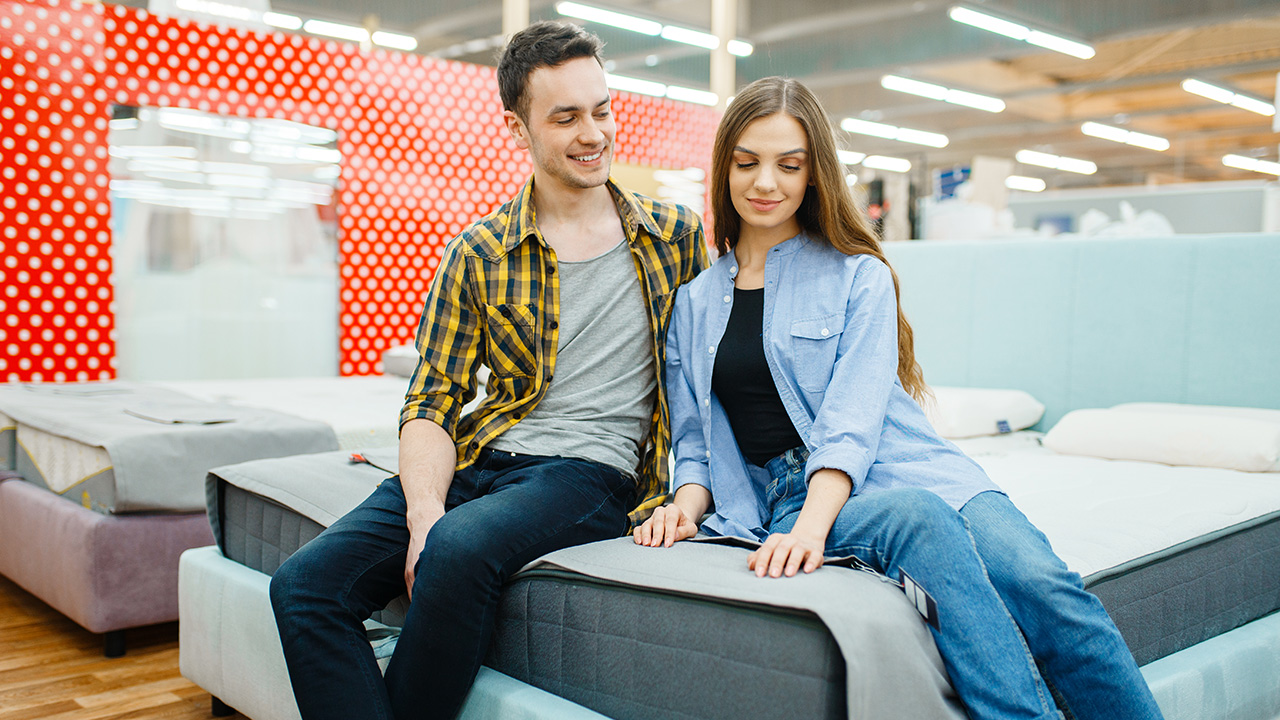 Couple Testing Bed in Furniture Store Showroom