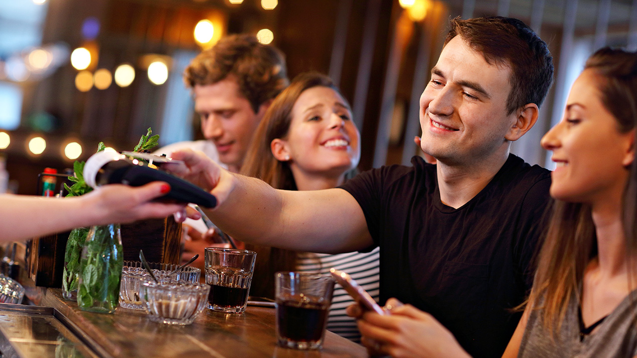 Group of Friends Paying for Meal in Restaurant