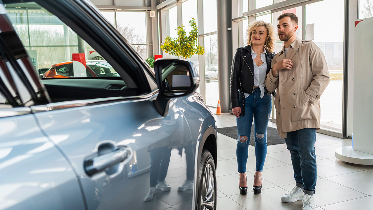 Couple in Car Dealership Looking at a Car