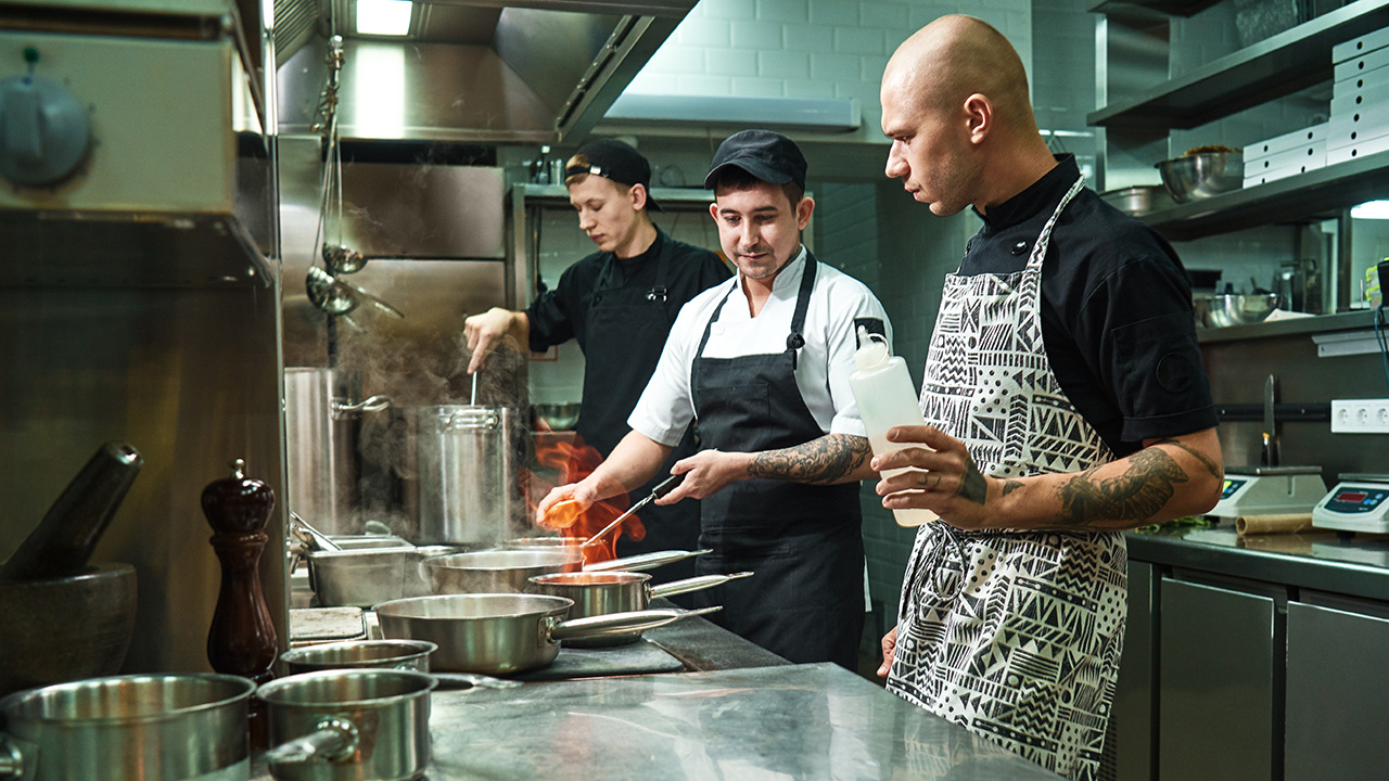 Professional Chef Teaching Trainees How to Flambe