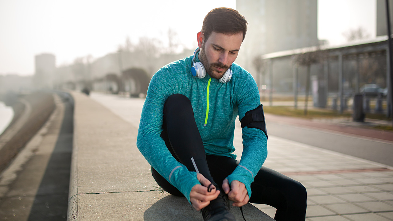 Young Man in Activewear Lacing Up for a Jog