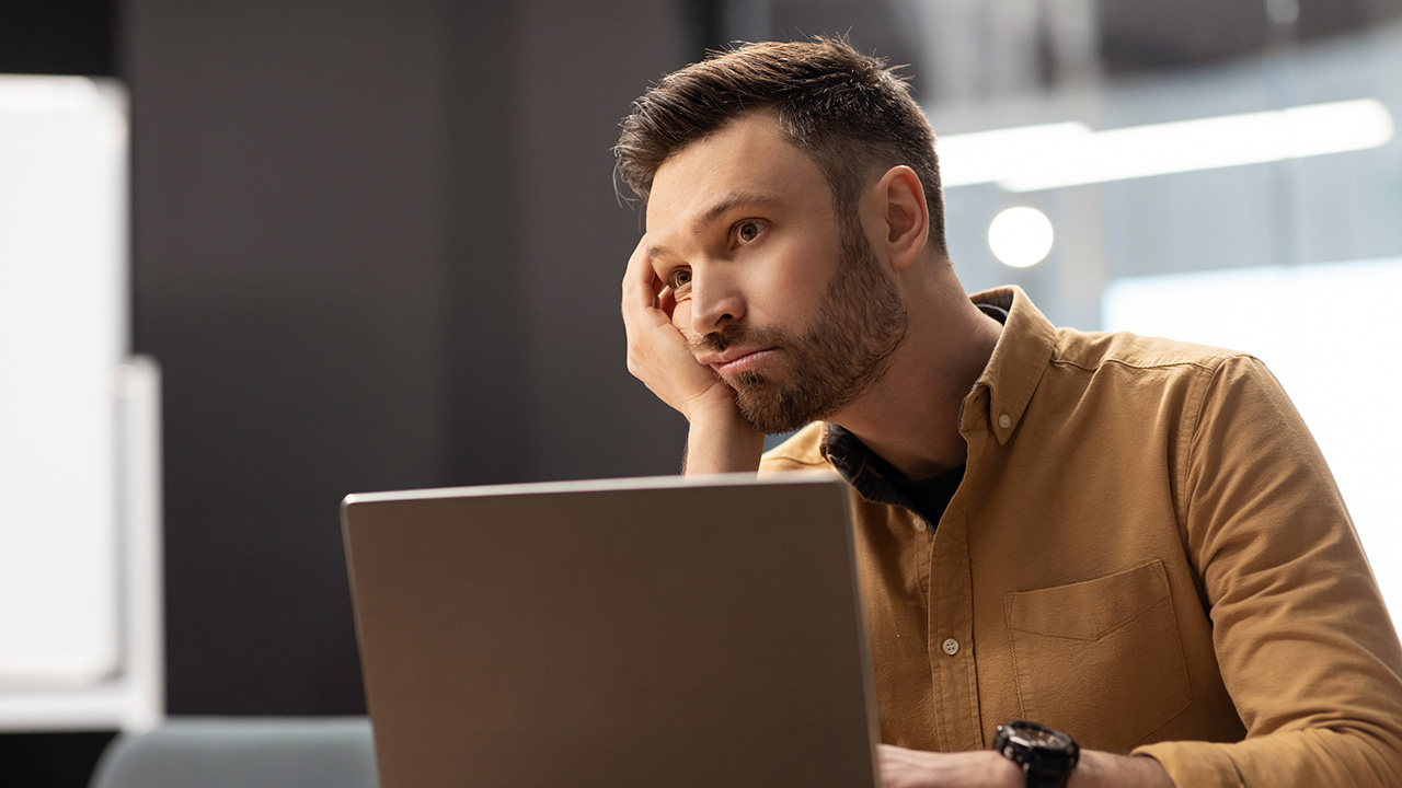 Bored Employee on Laptop in Modern Office